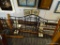 WOOD AND IRON CONVERTIBLE DAY BED; THIS BEAUTIFUL DAY BED HAS AN ARCHED BLACK IRON HEAD BOARD, AND