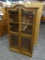 WOODEN CHINA CABINET; THIS CHINA CABINET HAS AN ARCHED TOP RAIL, TWO GLASS PANELED DOORS. EACH DOOR