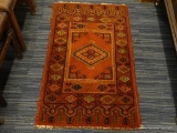 HAND KNOTTED AREA RUG; THIS RED HAND KNOTTED AREA RUG IS A MEDIUM PILE WITH A BLACK, AND TAN