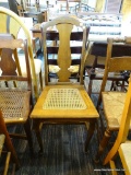 VINTAGE CANE SEAT CHAIR; WOODEN CHAIR WITH FIDDLE BACK SUPPORTED BY POSTS THAT LEAD DOWN TO A CANE