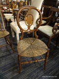 RUSH BOTTOM CHAIR; THIS CHAIR HAS A ROUND BACK WITH CARVED CENTER SUPPORTED BY TWO CARVED POSTS, A