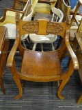 ANTIQUE CARVED WOODEN ARMCHAIR; REMARKABLY DETAILED CARVED DOG HEADS FLANK THE BACK PANEL OF THIS