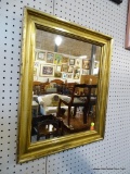FRAMED WALL MIRROR; RECTANGULAR MIRROR FRAMED IN AN AGED GOLD TONE FRAME. MEASURES 19.5 IN X 23.5