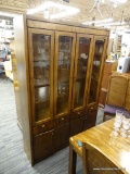 BERNHARDT CHINA CABINET; THIS LIGHTED CHINA CABINET HAS A CARVED TOP RAIL, TWO GLASS PANELED DOORS.