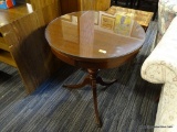 ROUND SIDE TABLE; ROUND SIDE TABLE WITH GLASS TOP SITTING ATOP A TURNED PEDESTAL BASE WITH SPLAYED