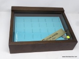 TABLETOP KNIFE DISPLAY CASE; WOODEN FRAME WITH GLASS TOP PANEL. TEAL PLASTIC TIERED INSERT AND