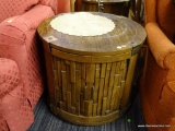 DRUM SHAPED END TABLE; GROOVED BORDER WITH 4 BRASS BRACKETS. ONE SIDE PANEL IS A DOOR WITH VERTICAL