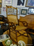 WOODEN ROCKING CHAIR WITH CANE BACK AND SEAT; SCALLOPED CREST RAIL OVER BANISTER SEGMENT ATOP CANE