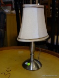BRUSHED SILVER COLORED DESK LAMP; COMES WITH OBLONG WHITE BELL SHAPED LAMPSHADE WITH GREY BORDERS.