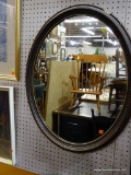 (WALL) FRAMED OVAL WALL MIRROR; VINTAGE GLASS MIRROR IN DARK WOODEN FRAME. MEASURES 25 IN WIDE AND