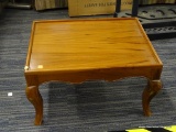 LOW WOODEN SIDE TABLE; RECTANGULAR SHAPED, LIGHT-MEDIUM FINISH, SABER LEGS WITH CARVED BORDER.