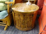 DRUM SHAPED END TABLE; GROOVED BORDER WITH 4 BRASS BRACKETS. ONE SIDE PANEL IS A DOOR WITH VERTICAL