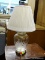 TABLE LAMP WITH ETCHED GLASS BASE; COMES WITH PLEATED OFF WHITE LAMPSHADE. MEASURES 21 IN TALL.