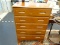 MAPLE CHEST OF DRAWERS; 5 DRAWER CHEST OF DRAWERS SITTING ATOP 4 TALL BRACKET STYLE FEET. HAS CARVED