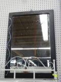 BLACK DECORATIVE WALL MIRROR; THIS HANGING RECTANGULAR MIRROR IS FRAMED IN A BLACK FRAME. IT HAS A