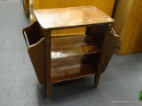 VINTAGE WOODEN TABLE WITH SIDE MAGAZINE RACKS AND LOWER SHELF; 2 SHELVES DOWN THE CENTER, AND A