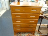 MAPLE CHEST OF DRAWERS; 5 DRAWER CHEST OF DRAWERS SITTING ATOP 4 TALL BRACKET STYLE FEET. HAS CARVED