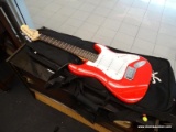 FENDER SQUIER MINI GUITAR; RED IN COLOR, INCLUDES STRAP AND SOFT-SIDED GIG BAG. A SMALLER VERSION OF