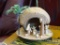 COCONUT HANDCRAFTED NATIVITY SCENE; MADE OF DOME-LIKE TAN MANGER WITH SMALL WOODEN FIGURES INSIDE,
