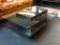 CONTEMPORARY GLASS TOP TIERED COFFEE TABLE; RECTANGULAR CENTER POST WITH GLASS TOP, AND BLACK