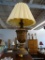 GOLD TONED LAMP; LARGE ACANTHUS LEAF PATTERN LAMP WITH BROWN BASE. HAS SHADE AND FINIAL. MEASURES 36