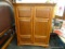 ENTERTAINMENT CENTER; HAS DENTIL MOLDED TOP AND 2 BEVELED PANELED DOORS, AND INSIDE HAS AN UPPER