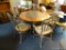 WROUGHT IRON ROUND TOP DINING SET; INCLUDES TABLE AND 5 CHAIRS. THE ROUND TABLE HAS A WOODEN TOP, A