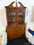 CHINA CABINET WITH BROKEN PEDIMENT TOP; 2 GLASS DOORS OVER 2 LOWER PANELED CABINET DOORS. FLAME
