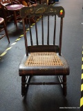 VINTAGE TOLE PAINTED ROCKING CHAIR WITH CANE SEAT; STAINED BLACK IN COLOR WITH SCALLOPED TOP RAIL,