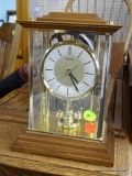 SEIKO WOOD/BRASS MANTEL CLOCK; MODEL #AQW 001B. MOLDED WOODEN TOP AND BASE WITH BRASS POSTS AND