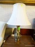 BRASS-BASE TABLE LAMP WITH CREAM COLORED BELL-SHAPED LAMPSHADE; HAS FINIAL AND HARP. MEASURES 24 IN