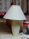 (BACK) CREAM COLORED TEXTURED TABLE LAMP; THIS TABLE LAMP HAS A CREAM COLORED BELL SHAPED SHADE THAT