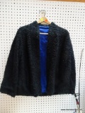 (BACK) BLACK CURLY WOOL COAT; BLACK WOMEN'S CURLY WOOL COAT WITH SIDE POCKETS. THIS IS AN OPEN