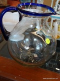 BALL WATER PITCHER; HAND BLOWN BALL SHAPED WATER PITCHER WITH COBALT BLUE RIM AND HANDLE. MEASURES