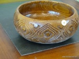 CARVED WOODEN BOWL; ROUNDED SIDES WITH GEOMETRIC FLORAL CARVED DESIGN. MEASURES 9 3/4 IN DIAMETER