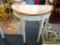HALF-MOON SHAPED HALL TABLE WITH WOOD GRAIN TOP AND CREAM SPECKLED BASE; OFF WHITE IN COLOR (FACTORY