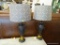URN SHAPED LAMPS; PAIR OF BRONZE TONED DOUBLE HANDLED URN SHAPED LAMPS WITH SHADES AND FINIALS.