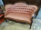 VICTORIAN LOVESEAT; MAHOGANY AND PINK UPHOLSTERED VICTORIAN LOVE SEAT WITH BUTTON TUFTED BACK AND IS