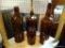 BROWN GLASS BOTTLES SHELF LOT; TOTAL OF 5 PIECES INCLUDING 3 TALL BOTTLES (1 OF WHICH IS MARKED MALT