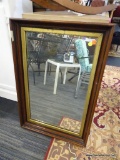 WOOD FRAMED WALL MIRROR; DARK WOODEN SHADOW BOX FRAME WITH BLACK AND GOLD BANDED TRIM. MEASURES 20