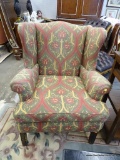 WINGBACK CHAIR; 1 OF A PAIR OF GREEN, GOLD AND RED TONED WINGBACK CHAIRS WITH MAHOGANY LEGS AND