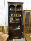 DARK STAINED PINE BOOKCASE/CABINET; CROWN MOLDED RAIL OVER DENTIL MOLDED TOP, CENTER DIVIDING POST