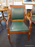 WOODEN ARMCHAIR WITH GREEN BACK AND SEAT AND RIVETED DETAIL; ROLLED WOODEN TOP RAIL WITH ARMS WHICH