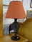 TABLE LAMP; BLACK WIRE AND URN SHAPED LAMP WITH RED BURLAP SHADE. MEASURES 7 IN X 29 IN