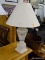 TABLE LAMP; WHITE WASHED WITH AN URN SHAPED BODY AND CREAM BELL SHAPED SHADE AND BALL FINIAL.