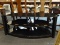 BLACK GLASS ENTERTAINMENT STAND; 2 SHELVES, UNIQUE MODERN SHAPE, MEASURES 50 IN X 20.5 IN X 20 IN