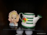 ASSORTED DECOR LOT; THIS 2 PIECE LOT INCLUDES A GREEN AND WHITE CERAMIC WATERING CAN, AND A STATUE