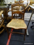 WOODEN SIDE CHAIR WITH CANE SEAT; HAS A ROSE CARVED CREST AND IS IN EXCELLENT CONDITION. MEASURES 17