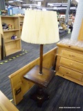 WOODEN FLOOR LAMP; HAS A SQUARE BUILT IN TABLE AND A PLEATED SHADE WITH FINIAL. MEASURES 57 IN TALL