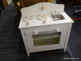 CHILDS TOY STOVE; WHITE PAINTED WITH CREAM AND PINK ACCENTS. HAS A SWING OPEN DOOR WITH 1 INTERIOR